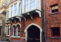 Interior room with wooden table, chairs and decorative mirrors on wall