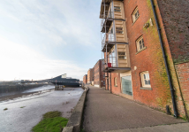 White house with blue roof and green garden in front, sunny day
